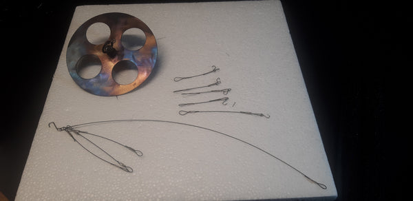 These are a few part that make up the wind chime. The round disk attaches to the long wire while the three strands hold the main ring. The 4-short strand connect the bottom of the ring to the 4-tubes. The last strand connects from the bottom of the ring to the striker.